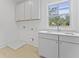 This laundry room features bright white cabinets, a stainless steel sink, and a window offering lots of natural light at 755 Adluh St, Mount Pleasant, SC 29464