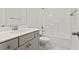 Well-lit bathroom featuring gray vanity, tile flooring, and bathtub with shower at 761 Maynard Ln, Summerville, SC 29486