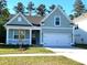 Charming, light-blue, one-story home featuring a two-car garage, manicured lawn, and welcoming front porch at 761 Maynard Ln, Summerville, SC 29486