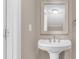 A pedestal sink with an ornate mirror and a light fixture is the focus of this cozy bathroom at 7838 Nummie Ct, North Charleston, SC 29418