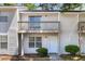 Two-story townhouse featuring a balcony, complemented by green shrubs and meticulous landscaping at 7838 Nummie Ct, North Charleston, SC 29418
