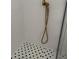 Close up of a shower with a black and white tile floor, white walls, and a gold shower head at 804 Temple Rd # B, Ladson, SC 29456