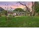 Spacious backyard with lush green grass, mature trees, and a charming brick home at sunset at 816 Farnham Rd, Charleston, SC 29412