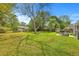 Large grassy backyard with mature trees and a patio perfect for relaxing and enjoying the outdoors at 816 Farnham Rd, Charleston, SC 29412