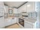 Traditional kitchen with white cabinetry, white appliances, and floral wallpaper at 816 Farnham Rd, Charleston, SC 29412