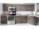 Well-lit kitchen featuring stainless steel appliances, ample gray cabinets, and speckled granite countertops at 8651 Grassy Oaks Trl, North Charleston, SC 29420
