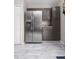 Open concept kitchen features a stainless steel refrigerator, ample gray cabinets and granite countertops at 8651 Grassy Oaks Trl, North Charleston, SC 29420