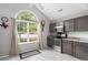 Well-lit kitchen with gray cabinets, stainless steel appliances, and a large window overlooking the yard at 8651 Grassy Oaks Trl, North Charleston, SC 29420