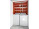 Functional laundry area with a white washer, dryer, and shelving for storage at 8651 Grassy Oaks Trl, North Charleston, SC 29420