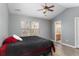 Comfortable bedroom featuring a high ceiling, ceiling fan, neutral color, and ample natural light from the window at 8653 Grassy Oak Trl, North Charleston, SC 29420