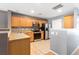Well-lit kitchen with tile floors, stainless appliances, and wood cabinets at 8653 Grassy Oak Trl, North Charleston, SC 29420
