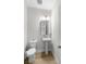 Neutral-toned powder room featuring pedestal sink, elongated toilet, wood-look flooring and modern mirror at 8654 Windsor Hill Blvd, North Charleston, SC 29420