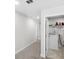 Hallway leading to laundry closet with a white washing machine on tile floor and storage shelving at 8654 Windsor Hill Blvd, North Charleston, SC 29420