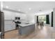 Modern kitchen with a gray island, stainless steel appliances, and a view into the dining area and living room at 8654 Windsor Hill Blvd, North Charleston, SC 29420