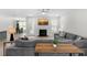 Open-concept living room with a fireplace, modern gray couches, and access to the backyard at 8654 Windsor Hill Blvd, North Charleston, SC 29420