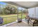 Screened in patio featuring a table and chairs, with a view of the yard and nature beyond at 8654 Windsor Hill Blvd, North Charleston, SC 29420