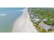 Breathtaking aerial view of beachfront homes along a pristine beach with lush vegetation at 1 Bay Ct, Isle of Palms, SC 29451