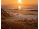 Inviting beach scene at sunrise featuring stairs to the beach and gentle waves at 1 Bay Ct, Isle of Palms, SC 29451