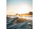 Beautiful shot of a surfer on a sunny morning with nearby homes and a light-filled sky at 1 Bay Ct, Isle of Palms, SC 29451