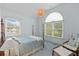 This well-lit bedroom features a four-poster bed, a hanging light fixture, large windows, and a chair with bench at 1 Bay Ct, Isle of Palms, SC 29451