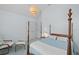 This bedroom features a four-poster bed, hanging light fixture, two windows, and chair with bench at 1 Bay Ct, Isle of Palms, SC 29451