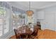 Bright dining room with a wooden table, shuttered windows, and decorative blue valances at 1 Bay Ct, Isle of Palms, SC 29451