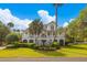 Charming two-story home with lush landscaping, a welcoming front porch, and classic architectural details at 1 Bay Ct, Isle of Palms, SC 29451