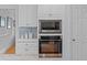 Modern kitchen featuring stainless steel appliances, custom white cabinets, and stylish tile backsplash at 1 Bay Ct, Isle of Palms, SC 29451