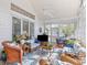 Relaxing sunroom with wicker furniture, ceiling fan, and screened windows offering serene views at 1 Bay Ct, Isle of Palms, SC 29451