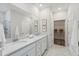 Bright bathroom features a double vanity, white cabinets, a large mirror, and modern fixtures at 1003 Sagegrass St, Summerville, SC 29485