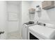 Well-organized laundry room with modern washer and dryer, shelving, and stylish tile floors at 1003 Sagegrass St, Summerville, SC 29485