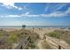 Scenic beach access to the ocean with volleyball and seating under a partly cloudy sky at 1004 Ocean Blvd # 108, Isle of Palms, SC 29451