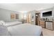 Comfortable bedroom featuring two beds, a flat-screen TV, mini fridge, and workspace with a charming bathroom at 1004 Ocean Blvd # 108, Isle of Palms, SC 29451