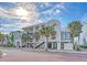 Exterior view of a condominium complex featuring balconies and palm trees and pedestrian brick road at 1004 Ocean Blvd # 108, Isle of Palms, SC 29451