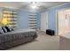 Bright bedroom with light blue walls, neutral carpet, and striped curtains at 1019 Spiers Cir, Bonneau, SC 29431