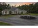 Scenic view of white single story house with front circular driveway, white trim, black shutters and sunset sky at 1019 Spiers Cir, Bonneau, SC 29431