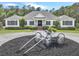 Charming exterior of home with decorative wagon planter in circular drive, manicured landscaping and inviting front entrance at 1019 Spiers Cir, Bonneau, SC 29431