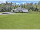Picture-perfect front exterior of a well-kept property featuring circular driveway, large manicured lawn and mature trees in the background at 1019 Spiers Cir, Bonneau, SC 29431