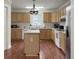 Well-lit kitchen with center island, wooden cabinetry, and white countertops at 1019 Spiers Cir, Bonneau, SC 29431