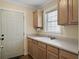 Bright mudroom features a built-in sink, wood cabinets, and an exterior door at 1019 Spiers Cir, Bonneau, SC 29431