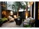 Cozy brick paved back patio featuring tropical landscaping, outdoor furniture, and ambient lighting at 104 May Ln, Mount Pleasant, SC 29464