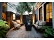 Cozy brick paved back patio featuring tropical landscaping, outdoor furniture, and ambient lighting at 104 May Ln, Mount Pleasant, SC 29464