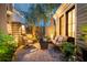 Cozy brick paved back patio featuring tropical landscaping, outdoor furniture, and ambient lighting at 104 May Ln, Mount Pleasant, SC 29464
