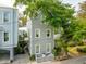 Charming two-story home featuring gray wood siding, white trim, and lush trees providing shade at 104 May Ln, Mount Pleasant, SC 29464