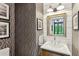 Stylish powder room featuring patterned wallpaper, shiplap accents, and a modern vanity at 104 May Ln, Mount Pleasant, SC 29464