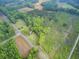 Wide aerial view of a secluded property featuring woods, open fields, and a road, offering privacy and accessibility at 1050 Mt Zion Rd, Saint George, SC 29477