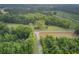 High angle shot of wooded area with open space, a house, and road, featuring a private, rural, and serene setting at 1050 Mt Zion Rd, Saint George, SC 29477