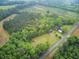 Expansive aerial view of lush land featuring a charming home and multiple outbuildings at 1050 Mt Zion Rd, Saint George, SC 29477