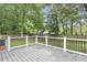 Outdoor deck with metal railing overlooking a grassy yard lined with mature trees and privacy fence at 106 Chaff Ct, Summerville, SC 29485