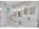 Luxurious bathroom showcasing a standalone tub, double vanity, and elegant decorative lighting at 108 Carolina Blvd, Isle of Palms, SC 29451